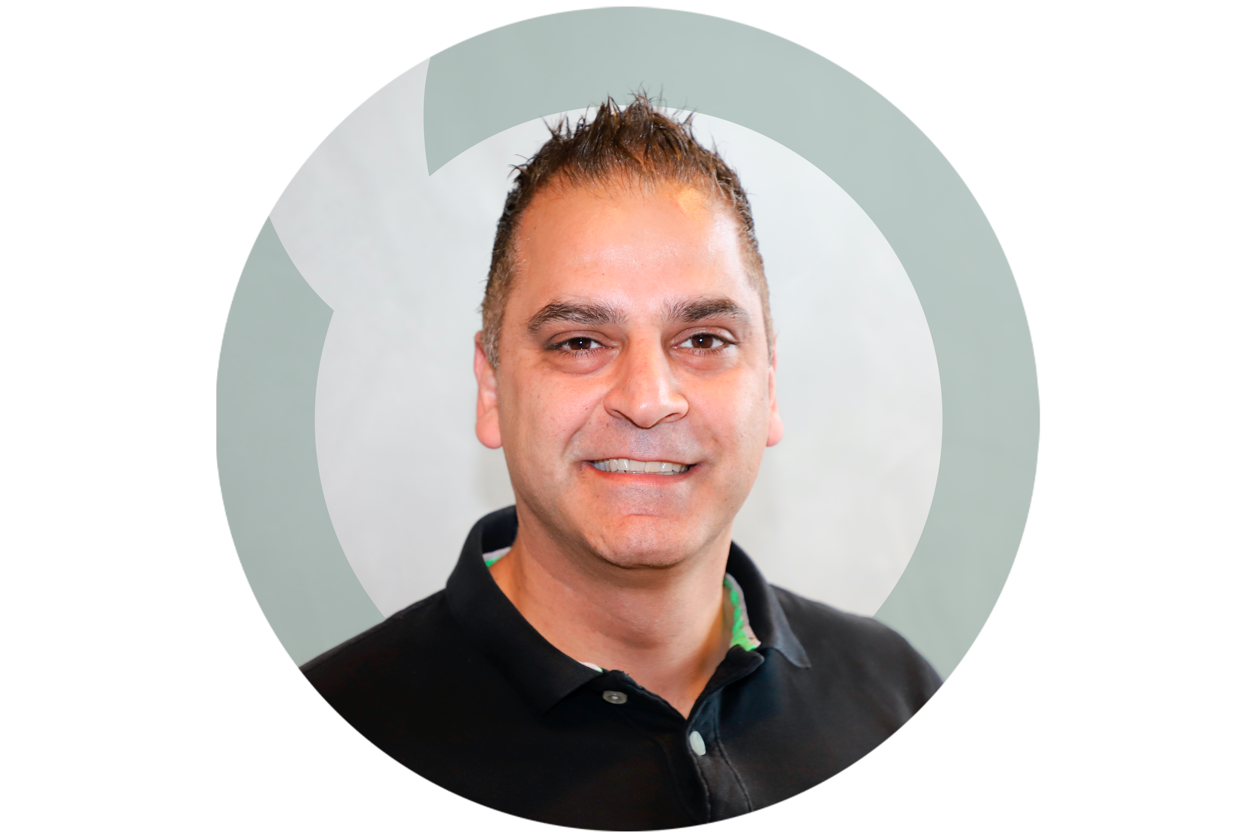 A man with short brown hair, wearing a black collared shirt, smiling at the camera.